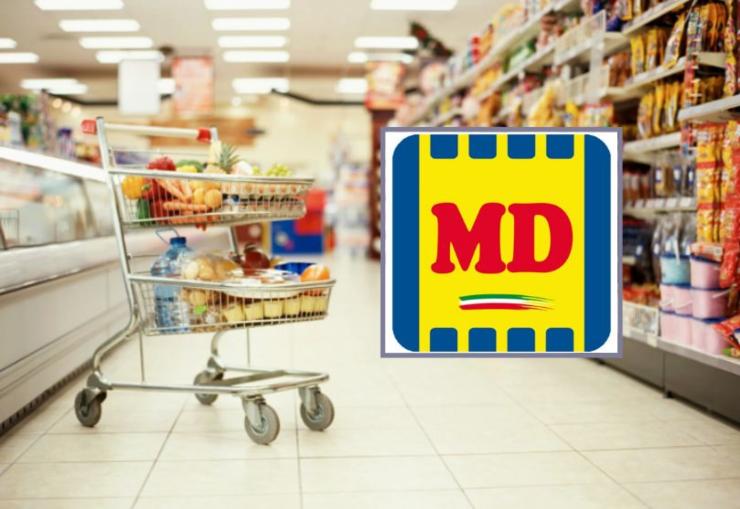 carrello in mezzo ad una corsia del supermercato e logo MD