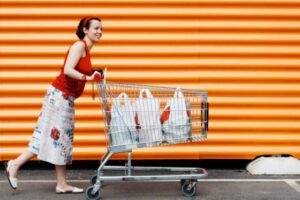 donna che spinge il carrello della spesa pieno di sacchetti