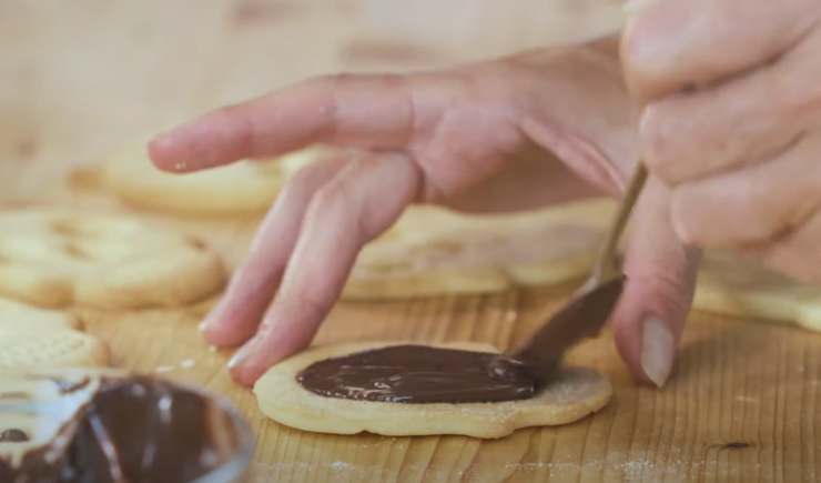 Mani riempiono biscotti di cioccolato