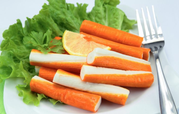 surimi con insalata e una fettina di limone e accanto una forchetta