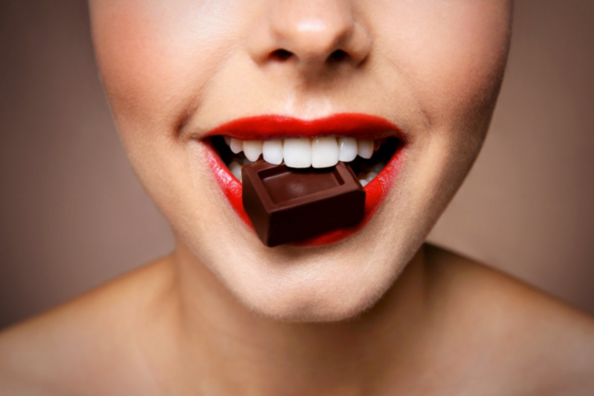 donna che morde un quadratino di cioccolato