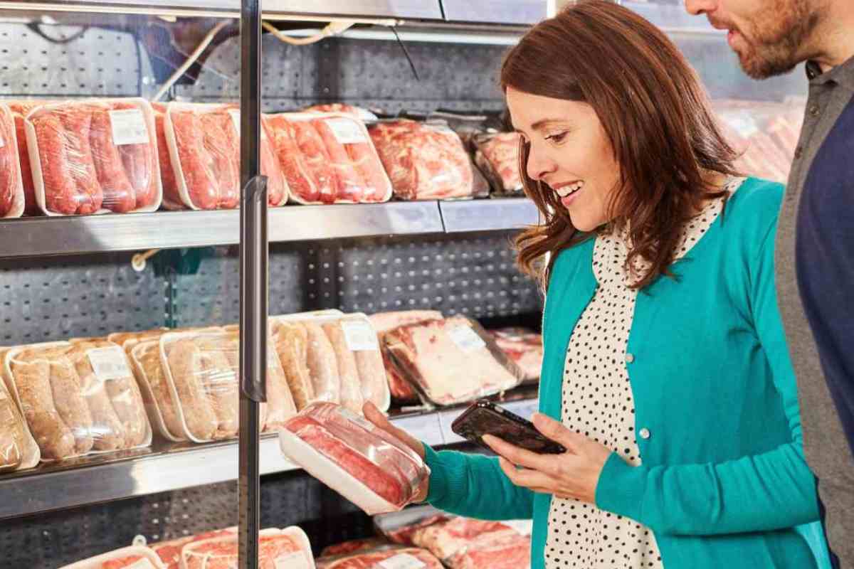 donna con confezione di carne in mano