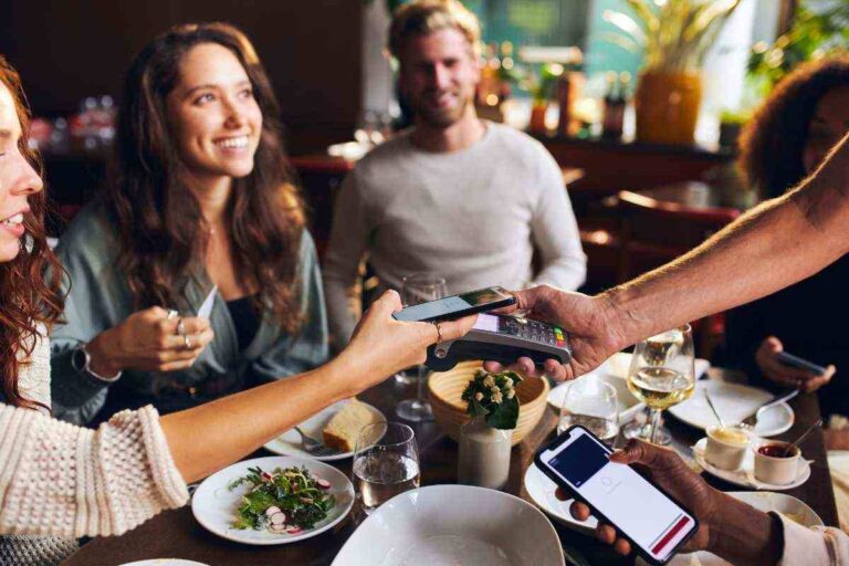 persone sorridenti sedute al tavolo al ristorante