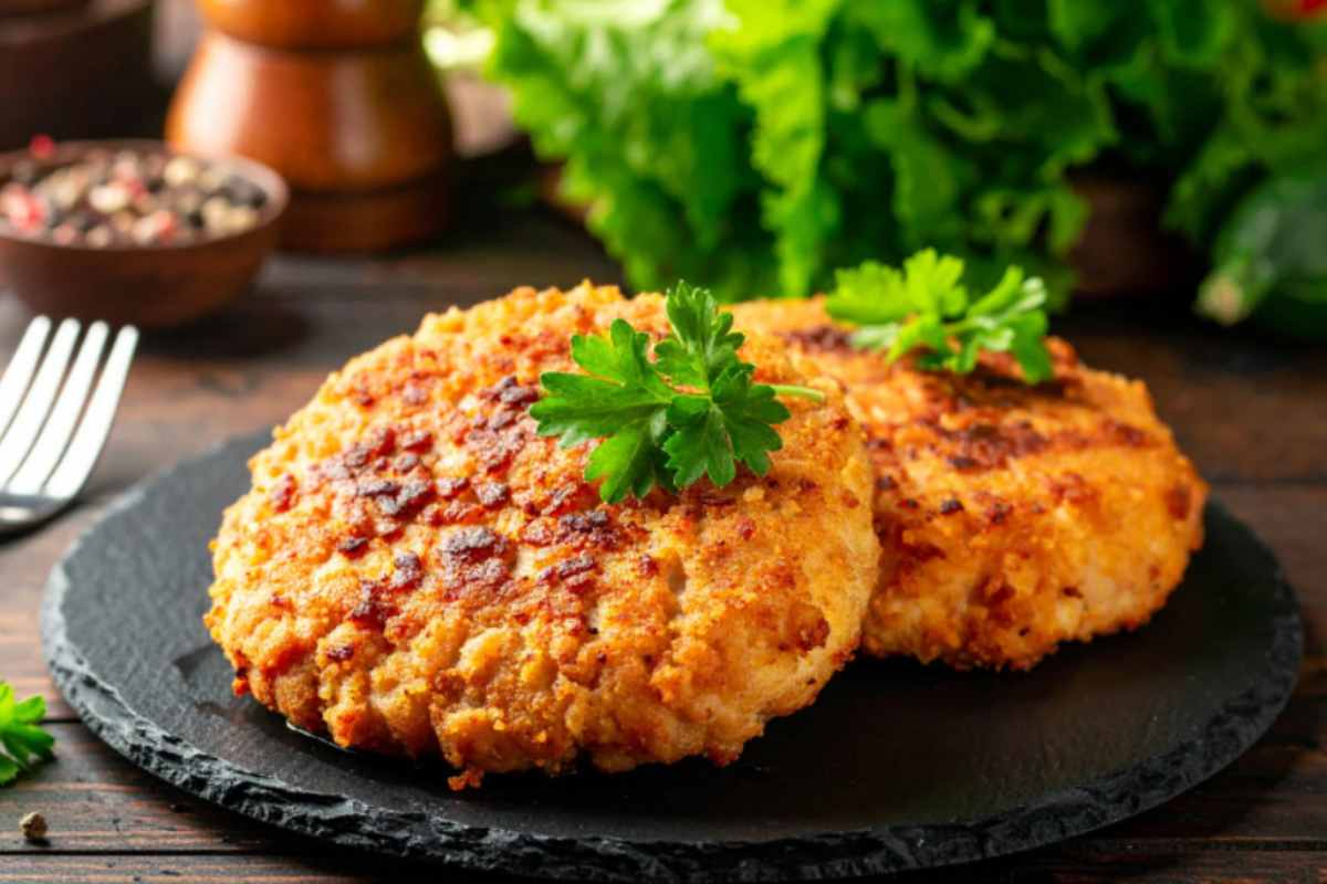 cotolette croccanti sopra ad un piatto con dietro dell'insalata