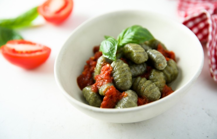 gnocchi di spinaci con salsa al pomodoro e dietro dei pomodorini