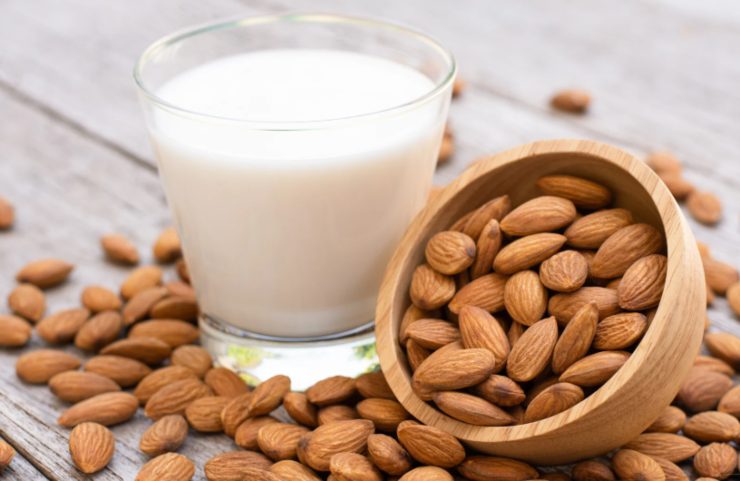 bicchiere di latte di mandorla e intorno delle mandorle