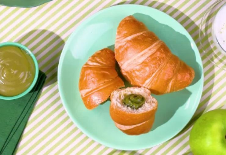 croissant al pistacchio bauli su un piatto con accanto della crema al pistacchio