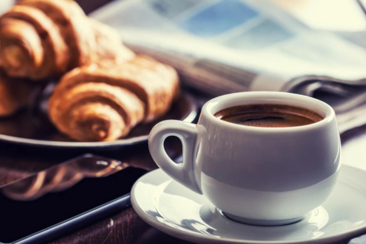 tazzina di caffè e accanto delle brioche