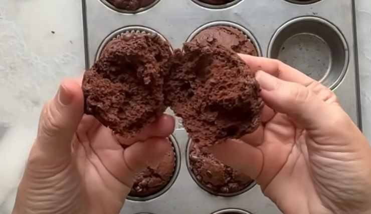 muffin aperto in due con le mani