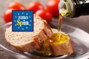 persona che versa dell'olio su una fetta di pane e logo eurospin