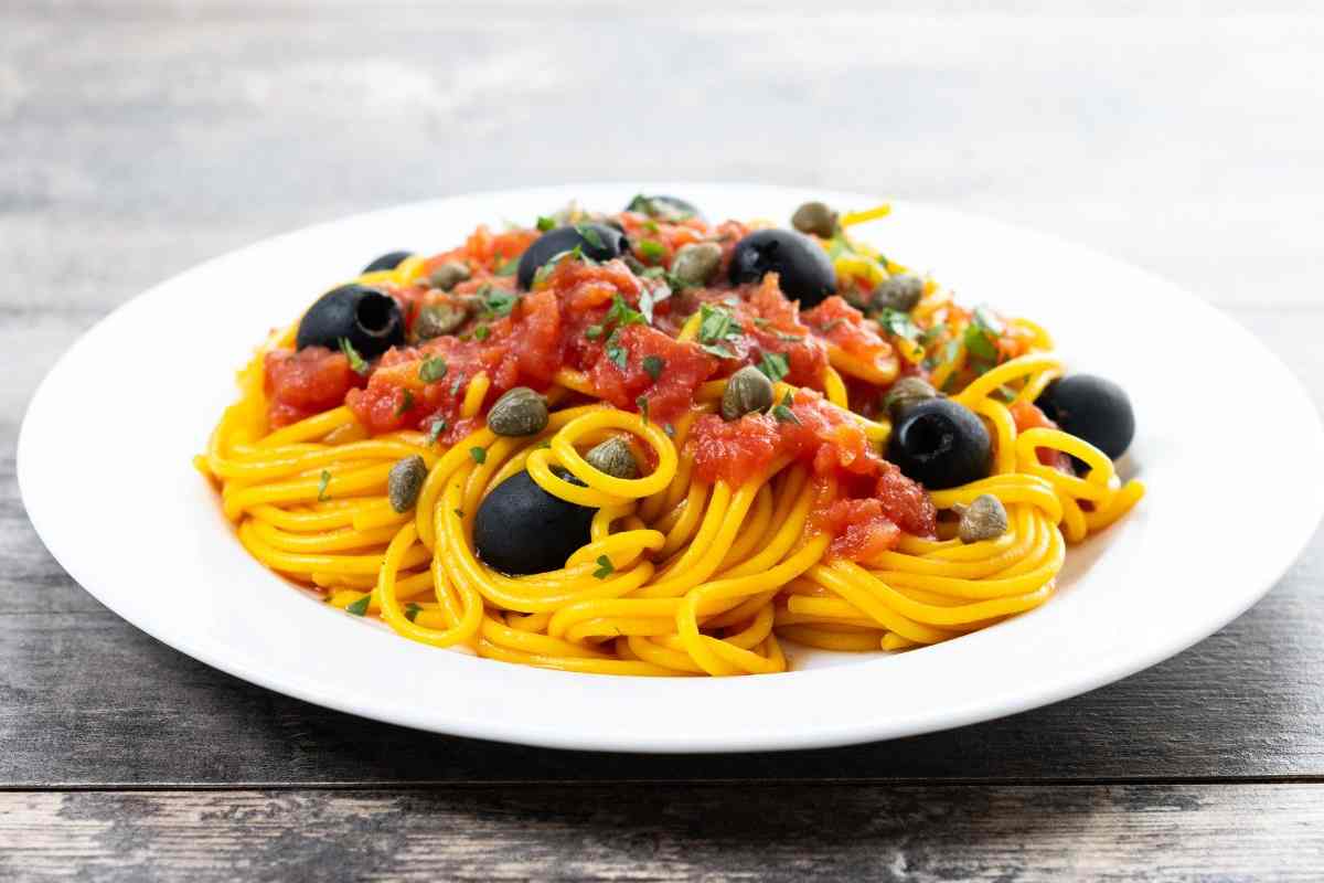 spaghetti con sugo di pomodoro, olive e capperi