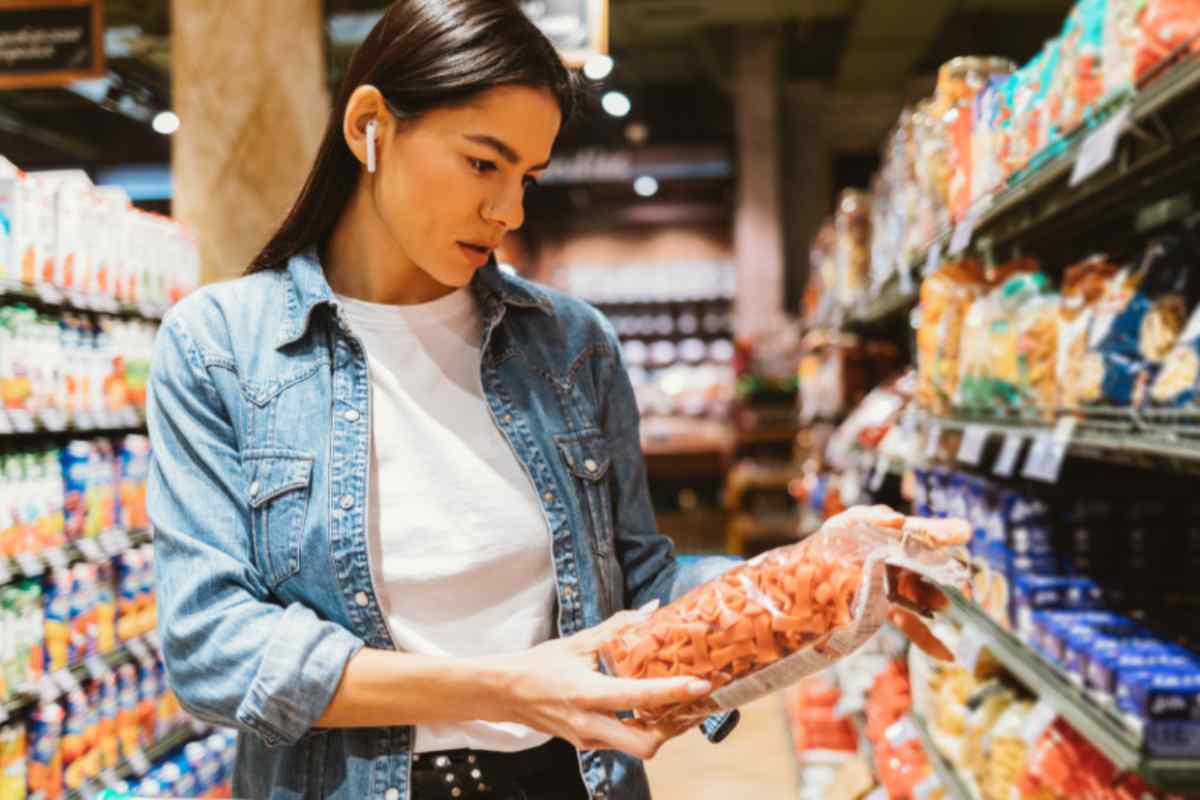 donna al supermercato che sceglie la pasta