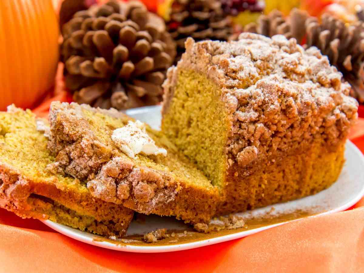 un plumcake alla zucca in un piatto con pigne dietro