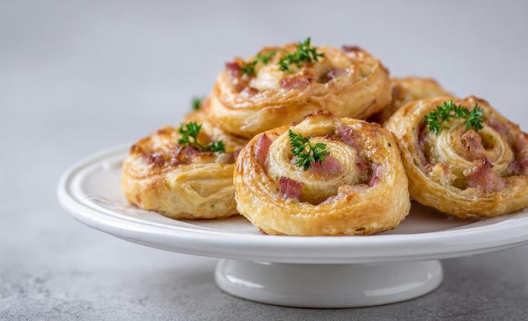 piatto con rosette di pasta sfoglia e prosciutto