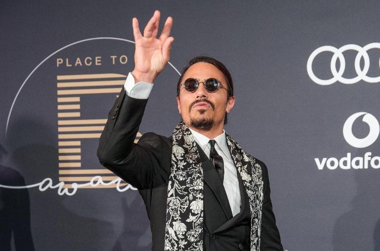 salt bae in primo piano con mano alzata