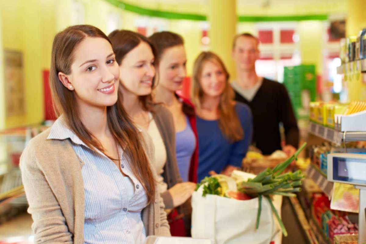 donna che sorride alla cassa del supermercato